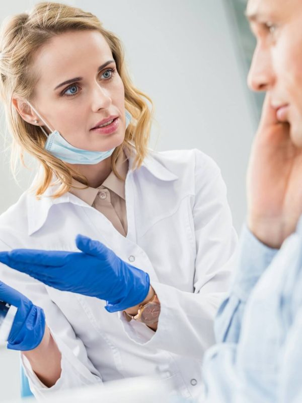 man-consulting-with-dentist-looking-at-x-ray-in-modern-clinic.jpg